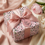 Elegant pink floral wrapping paper with a luxury satin bow by Wrapped Studios, perfect for birthdays.