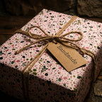 Pink floral wrapping paper with a rustic twine bow and handmade gift tag by Wrapped Studios.