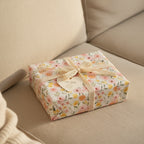 Floral wrapping paper on a gift box tied with a delicate lace ribbon, from Wrapped Studios.