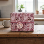 Elegant floral wrapping paper in blush pink with a twine bow on a gift box, perfect for birthdays or special occasions.