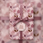 Elegant gift wrapped in pink floral wrapping paper with mauve ribbon, perfect for a special occasion.