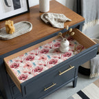 Pink floral wrapping paper used as a drawer liner in a navy dresser by Wrapped Studios.