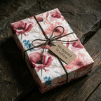Pink floral wrapping paper with rustic twine and a Wrapped Studios tag on a vintage-style gift box.