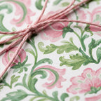 Pink and green floral wrapping paper tied with matching twine, elegant luxury gift wrap by Wrapped Studios.