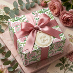 Luxury floral wrapping paper by Wrapped Studios on a gift box with a pink satin bow and 'With Love' tag.
