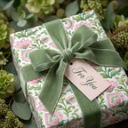 Luxury pink floral wrapping paper with a sage green velvet bow and gift tag by Wrapped Studios.