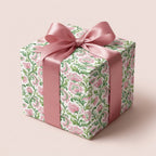 Vintage watercolor pink floral wrapping paper with a satin ribbon bow on a gift box by Wrapped Studios.