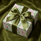 Luxury botanical floral wrapping paper with a green satin bow on a gift box by Wrapped Studios.