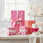 Elegant pink floral wrapping paper on gifts tied with silk ribbons.