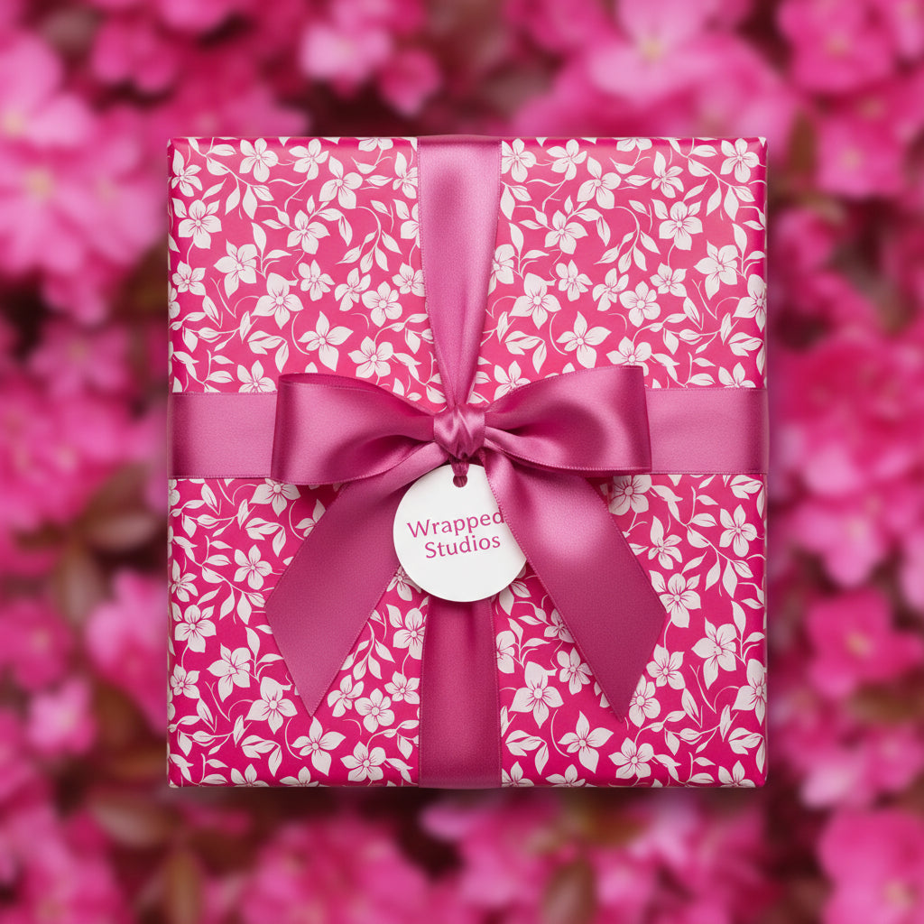 Square gift box in pink floral wrapping paper, tied with a matching pink satin ribbon.
