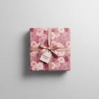 Square gift wrapped in blush floral wrapping paper with a matching satin bow.