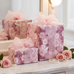 Elegant pink floral wrapping paper with sheer ribbon bows on gifts, plus roses and pearls.