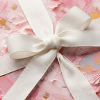 Elegant pink floral wrapping paper with a white ribbon bow, perfect for birthday gifts.