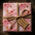 Elegant pink floral wrapping paper with twine bow, gift tag by Wrapped Studios.
