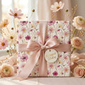 Elegant pink floral wrapping paper by Wrapped Studios on a gift box with a dusty rose satin bow.