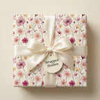 Botanical pink floral wrapping paper with a cream satin bow, luxury gift wrap by Wrapped Studios.