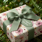 Elegant wildflower floral wrapping paper with a sage green ribbon bow by Wrapped Studios.