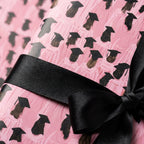 Pink graduation wrapping paper with a cap and gown pattern and black satin ribbon bow by Wrapped Studios.
