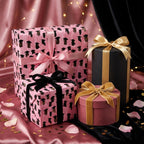 Pink graduation wrapping paper with graduate cap illustrations on luxury gift boxes by Wrapped Studios.