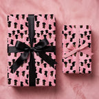 Pink graduation wrapping paper with graduate cap pattern and satin ribbons by Wrapped Studios.