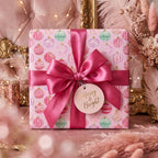 Pink ornament Christmas gift wrap with luxury satin ribbon and Merry & Bright tag by Wrapped Studios.