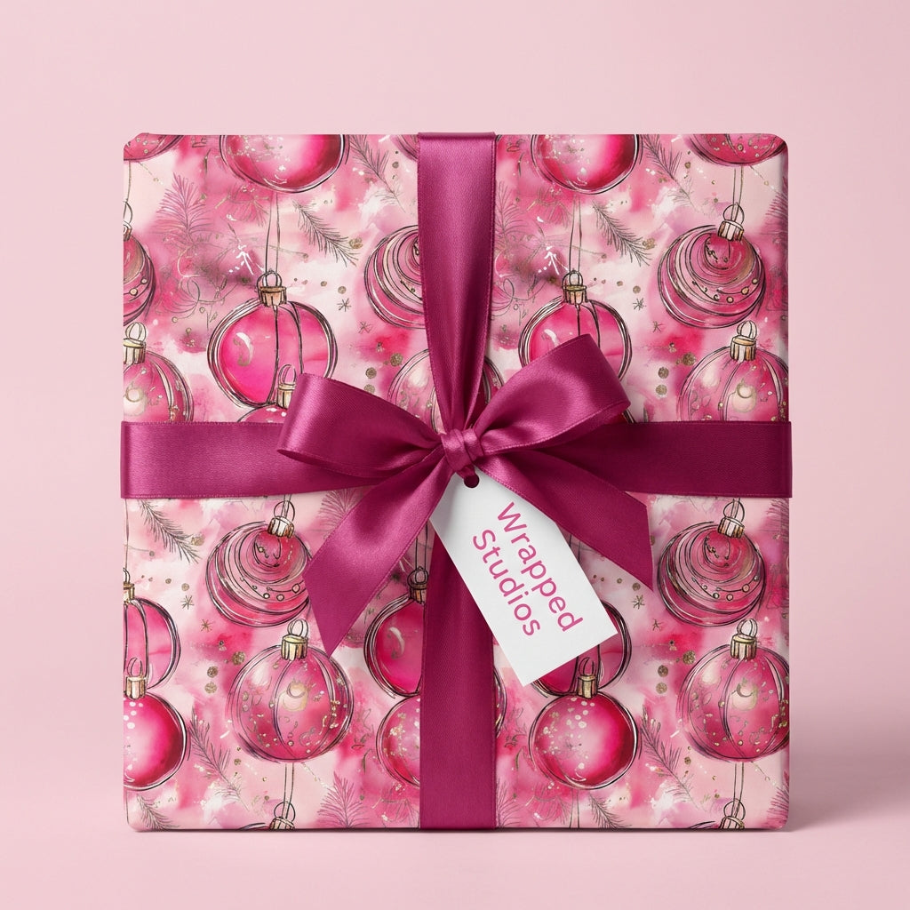 Wrapped Studios pink Christmas wrapping paper with ornament design and dark pink ribbon.