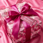 Wrapped Studios pink Christmas gift wrap with magenta satin ribbon.