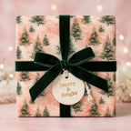 Luxury pink Christmas wrapping paper with watercolor pine trees and a green velvet bow by Wrapped Studios.