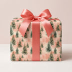 Pink Christmas tree wrapping paper with a coral satin bow on a gift box by Wrapped Studios.