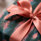 Luxury Christmas gift wrap with pink pine tree pattern and a satin bow by Wrapped Studios.