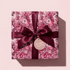 Wrapped Studios luxury Christmas gift wrap, floral design with burgundy ribbon.