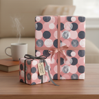 Two gifts wrapped in modern pink, gray, and white dot patterned wrapping paper with ribbon.