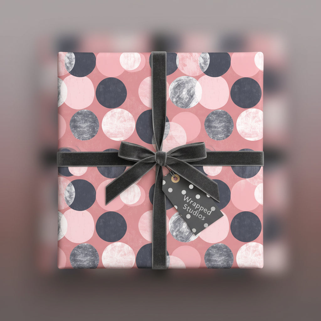Square gift box wrapped in modern pink polka dot wrapping paper with a grey velvet ribbon and gift tag.