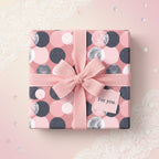 Elegant gift wrapped in pink modern geometric wrapping paper with ribbon bow and "For you" tag.