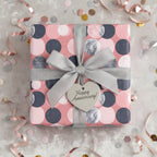 Happy Anniversary gift wrapped in modern pink dot wrapping paper with a silver ribbon and heart tag.