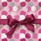 Close-up of a gift wrapped in pink patterned wrapping paper with a burgundy satin ribbon bow.