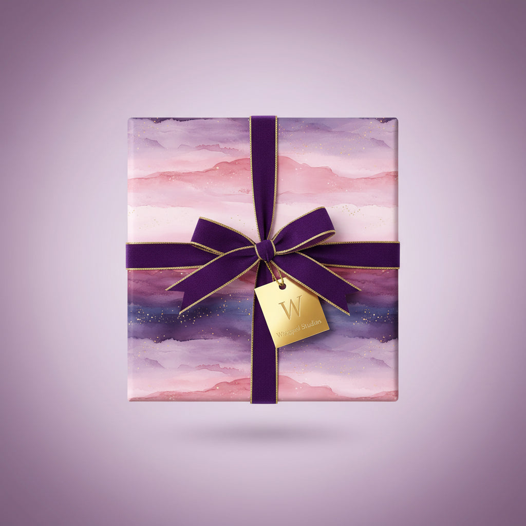Elegant square gift wrapped in pink and purple watercolor-style paper with a deep purple ribbon.