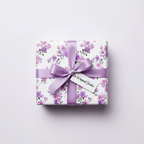 Elegant purple floral wrapping paper with a lavender ribbon and "Wrapped Studies" gift tag, perfect for a luxury birthday gift.