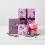 Elegant gifts wrapped in purple floral wrapping paper with ribbons for a special occasion.