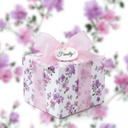 Elegant floral wrapping paper with purple and pink blossoms, tied with a sheer pink ribbon and "Finally!" tag, perfect for luxury wedding or bridal shower gifts.