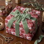Vintage pink rose floral wrapping paper with a sage green velvet bow on a gift box by Wrapped Studios.