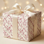 Luxury pink floral wrapping paper by Wrapped Studios on a gift box with a cream satin bow.