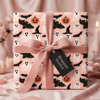 Pastel pink Halloween gift wrap with cute ghosts and bats, tied with a dusty pink velvet bow by Wrapped Studios.