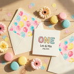 Pastel first birthday invitation with watercolor balloon envelope liners by Wrapped Studios.