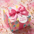 Pastel balloon birthday wrapping paper by Wrapped Studios with a pink satin bow and Happy Birthday tag.