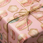 Pink baby shower wrapping paper with watercolor drums and gold bow, Wrapped Studios.