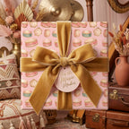 Pink drum and tambourine wrapping paper with a luxury gold velvet bow by Wrapped Studios.
