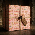 Pink vintage drum wrapping paper on a gift box with rustic twine by Wrapped Studios.