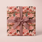 Western wrapping paper with horses and desert flowers on a gift box with a mauve bow by Wrapped Studios.