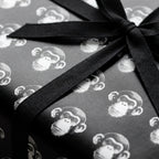 Black and white monkey wrapping paper with a textured black ribbon bow by Wrapped Studios.